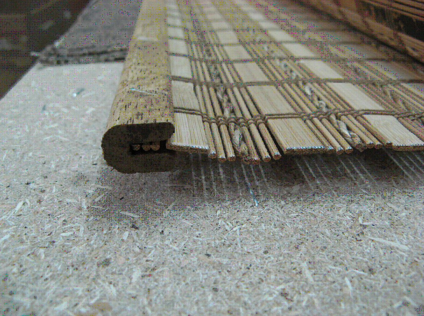 Производство бамбуковых ролет: полотно вставляется в нижнюю планку